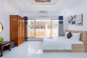 a bedroom with a bed and a large window at A5 Ngọc Tước - Villa Hồ Bơi Gần Biển Bãi Sau - Free Bida + Karaoke in Vung Tau
