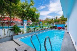 a pool at a hotel with chairs and trees at A5 Ngọc Tước - Villa Hồ Bơi Gần Biển Bãi Sau - Free Bida + Karaoke in Vung Tau +38 photos
