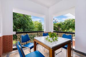 a balcony with a wooden table and blue chairs at A5 Ngọc Tước - Villa Hồ Bơi Gần Biển Bãi Sau - Free Bida + Karaoke in Vung Tau