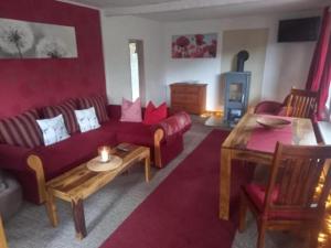 ein Wohnzimmer mit einem roten Sofa und einem Tisch in der Unterkunft Ferienhaus im Odertal in Stolpe