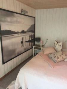 ein Schlafzimmer mit einem Bett mit einem großen Bild an der Wand in der Unterkunft Ferienhaus im Odertal in Stolpe