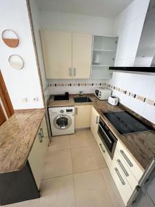 een kleine keuken met witte kasten en een fornuis bij Apartamento 1ª línea Patacona in Valencia