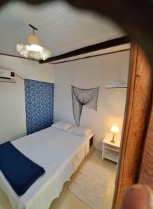 Hospedaria Fabulosa في باراتي: غرفة صغيرة بسريرين ومصباح
