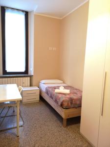 1 dormitorio con cama, escritorio y ventana en Loreto Elite Milano, en Milán
