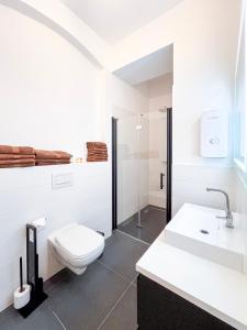 een witte badkamer met een toilet en een wastafel bij Apartment near Ku'damm in Berlijn +14 foto's