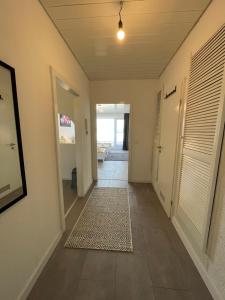 un pasillo de una casa con una puerta y una alfombra en Premium Apartment 4, en Pachten
