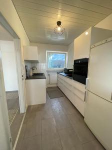 una cucina con armadietti bianchi e frigorifero di Premium Apartment 4 a Pachten