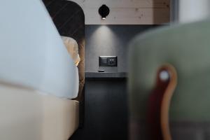 グリンデルワルトにあるHotel Central Wolter - Grindelwaldのベッド1台、デスク、ベッドサイドシックスが備わる客室です。