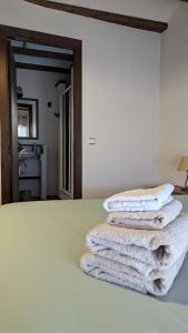 three towels stacked on a bed in a room at Cal Tous, La Socarrimada in Rojals