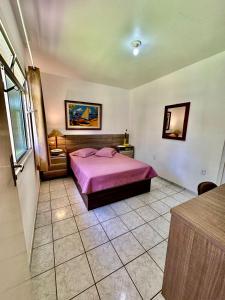 1 dormitorio con 1 cama rosa en una habitación en Flat da Graça, en Palhoça