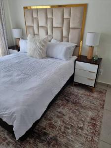 a bedroom with a large bed with a large headboard at Crestline2 at Emeraldskye in Lombardy East