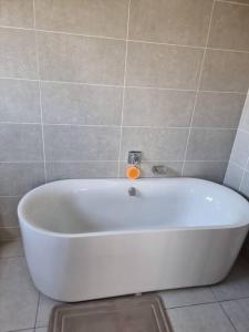 y baño alicatado con bañera blanca. en Crestline2 at Emeraldskye en Lombardy East