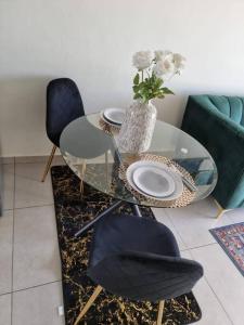 einem Glastisch mit zwei Stühlen und einer Vase aus Blumen in der Unterkunft Crestline2 at Emeraldskye in Lombardy East