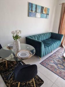 sala de estar con sofá azul y mesa de cristal en Crestline2 at Emeraldskye en Lombardy East