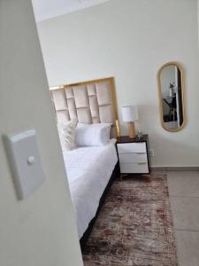1 dormitorio con 1 cama grande y espejo en Crestline2 at Emeraldskye en Lombardy East