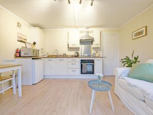 a kitchen and living room with a couch and a table at Elm Lodge in Bosham