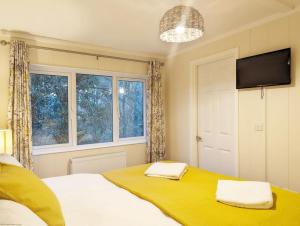 a bedroom with a bed with two towels on it at Elm Lodge in Bosham