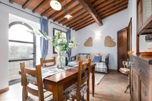 cocina y comedor con mesa de madera y sillas en Agriturismo Poggio Leone, en Gambassi Terme