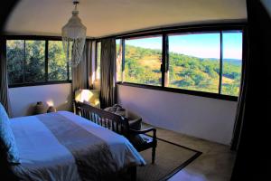 a bedroom with a bed and a large window at African Safari Lodge in Grahamstown
