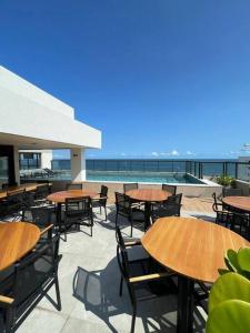 an outdoor patio with tables and chairs and the ocean at A BAHIA ACALMA in Salvador