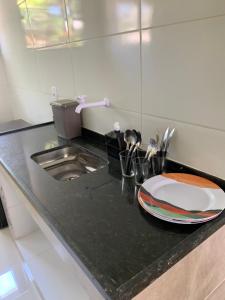 a kitchen counter with a sink and a plate on it at Mini Casa 02 em Cabo Frio in Cabo Frio