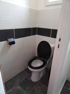 a bathroom with a toilet with a black seat at Tourmalet in Campan