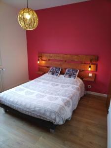 a bedroom with a large bed with a red wall at Tourmalet in Campan