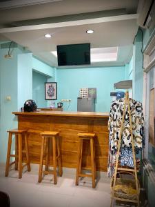 a bar with stools in a room with blue walls at Wesbobo inn Solo in Solo