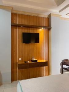 a bedroom with a tv on a wooden wall at Wesbobo inn Solo in Solo