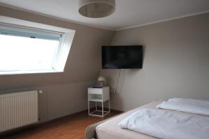 a bedroom with a bed and a television on the wall at Moderne Dachgeschosswohnung mit 2 Schlafzimmern in Würzburg