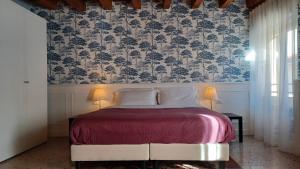 una camera da letto con un letto e carta da parati floreale di B&B Opera Prima a Verona