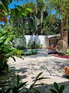 einen Garten mit einem Pool, einer Bank und Bäumen in der Unterkunft Hotel Boutique Vila São João in Trancoso