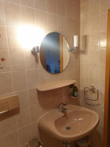 ein Bad mit einem Waschbecken und einem Spiegel in der Unterkunft Landhaus Bad Rotenfels - Zion in Gaggenau