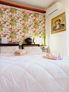 a bedroom with a white bed with a wallpaper with palm trees at B&B La Delice in Dalmine