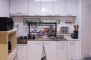 a kitchen with white cabinets and a sink at JB Stay#Hongdae & Sinchon 10min#Double Room in Seoul