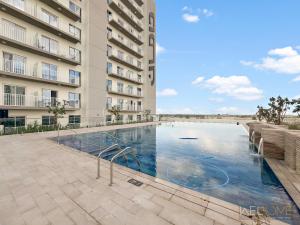 una piscina frente a un edificio en WelHome - Breathtaking View 1BR Apt in Damac Hills 2 en Dubái
