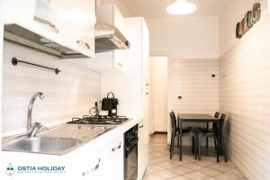 a kitchen with a sink and a table at Appartamento Tramontana in Lido di Ostia