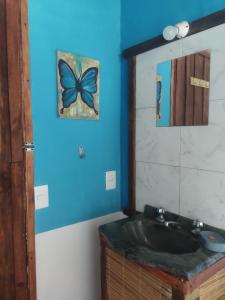 baño con lavabo y pared azul en Cabaña La Federica, en La Paloma