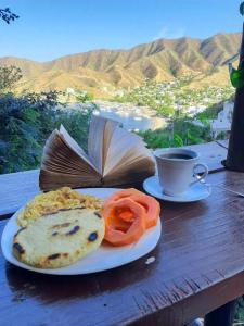 een bord eten met een boek en een kopje koffie bij Tamarindo Beach hostel in Taganga