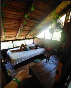 Tamarindo Beach hostel في تاجانجا: امرأة مستلقية على سرير في غرفة