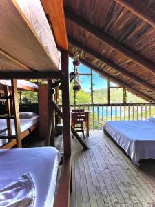 Tamarindo Beach hostel في تاجانجا: سطح خشبي كبير مع سريرين وطاولة