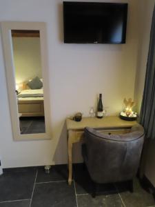 Habitación con escritorio con silla y espejo. en B&B Den Bruynen Bergh, en Beernem