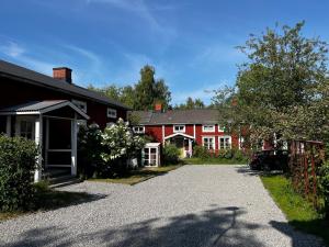 a red house with a driveway in front of it at The Guest House. in Gammelstaden