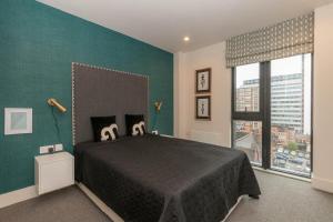 a bedroom with a large bed and a green wall at Rooms in Birmingham City Centre in Birmingham