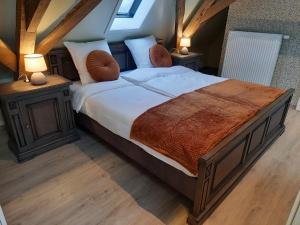 a bedroom with a large bed with two night stands at B&B Den Bruynen Bergh in Beernem