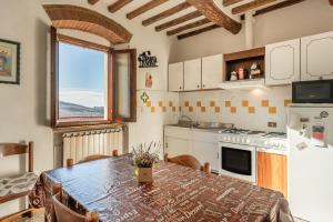 cocina con mesa con sillas y ventana en Casa Claire en Prataccio