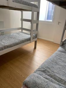 een slaapkamer met 2 stapelbedden en een houten vloer bij Casa Augusta 4 in Braga