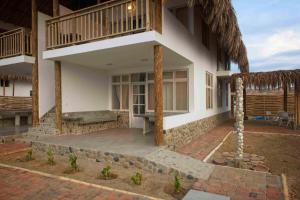 a house with a porch and a patio at Modern Appartments with private beach in Máncora