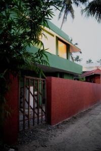 a red fence in front of a building at Summer beach house Alleppy beach in Alleppey +5 photos