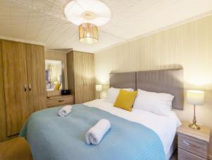 a bedroom with a large bed with two white towels on it at Red Oak - Bosham in Bosham